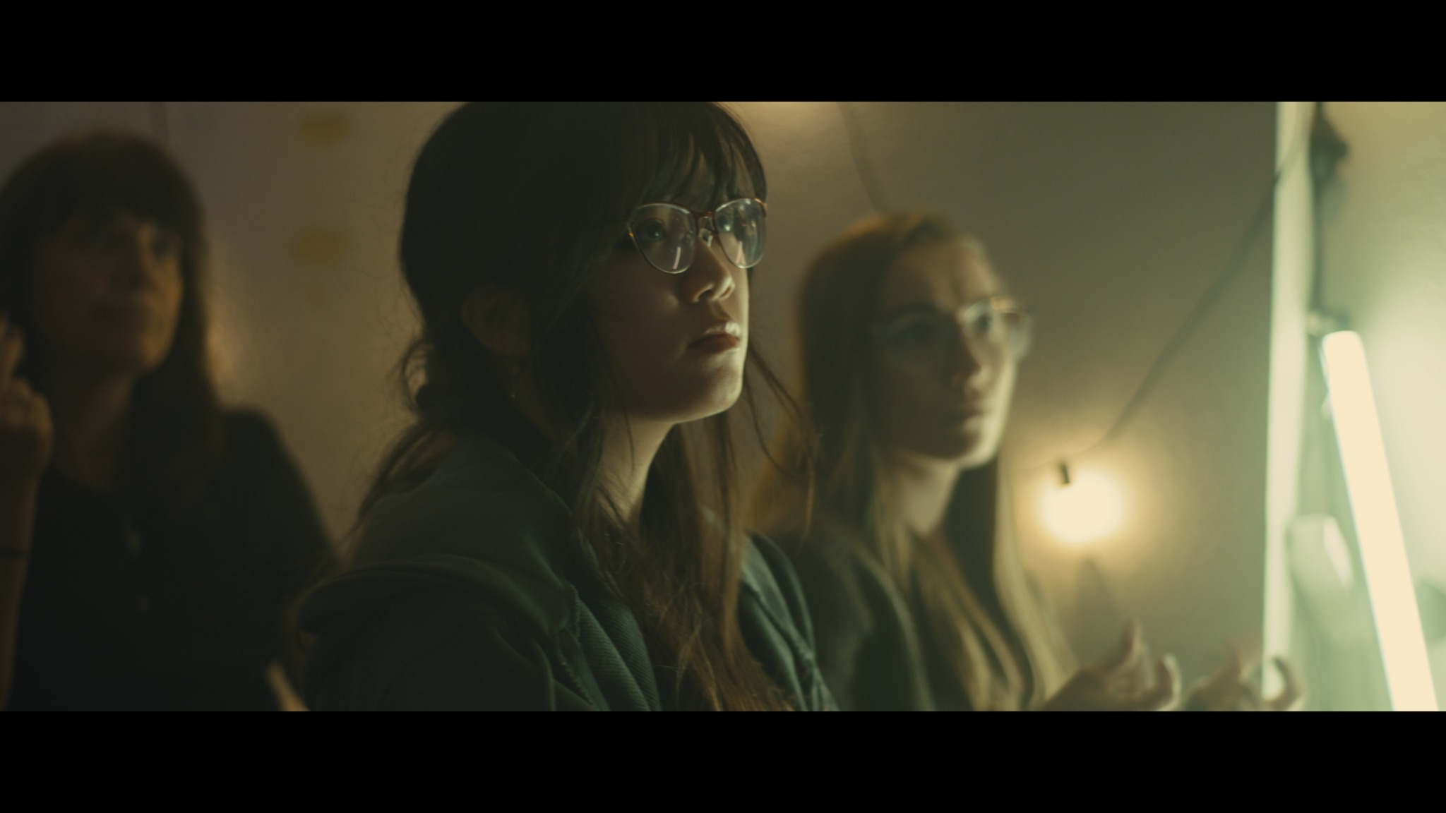 Woman with glasses in dim lighting